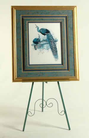Metal easel with tall framed art print with peacock