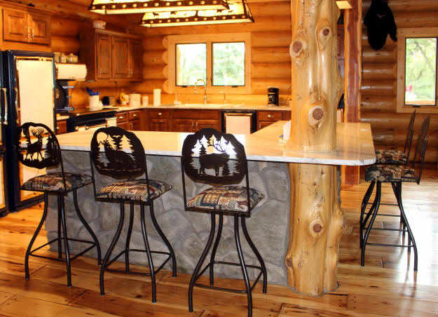 Residential home with rustic lodge swivel bar stools seated around a very rustic designed kitchen